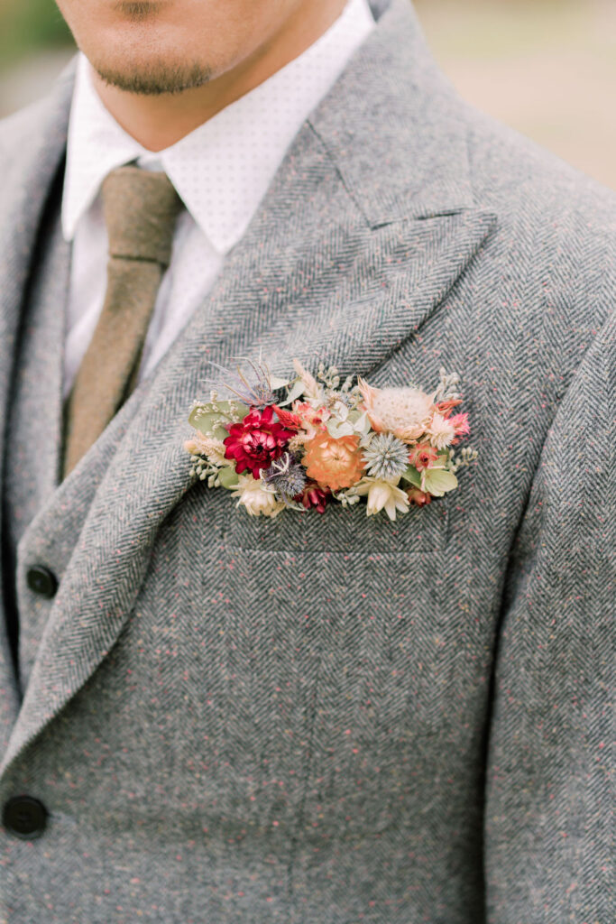 Groom wearing gray tweed suit with pocket boutonniere