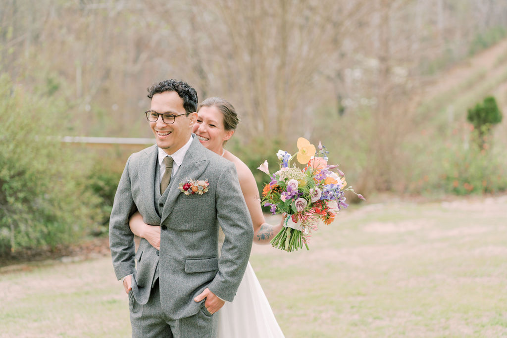 First look with couple and bright spring wedding bouquet