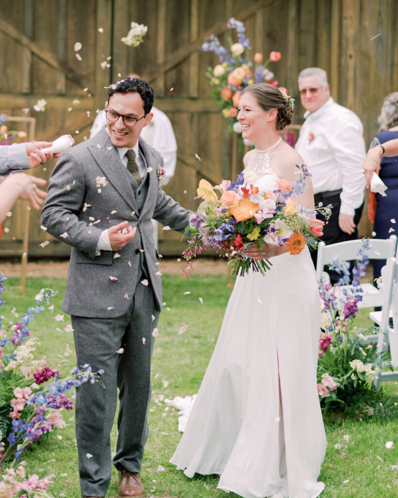 Bride and groom at ceremony exit with floral petal exit