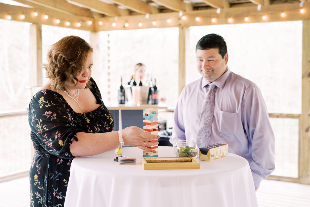 Guests with table top games during cocktail hour on covered porch