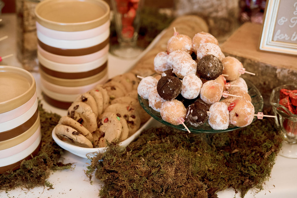 Dessert display at wedding reception with donut holes and cookies.